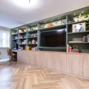 Fitted shelving and cupboards around TV β alterations by Fen Developments