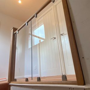 Oak and glass balustrade on landing β carpentry by Fen Developments