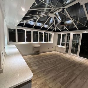 Conservatory with glazed roof and wood-effect floor β building work by Fen Developments