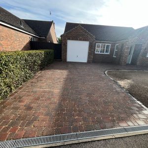 Block-paved driveway leading to garage β building work by Fen Developments