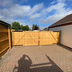 Timber double gates across block-paved driveway β building work by Fen Developments