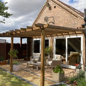 Timber pergola over patio beside brick house β building by Fen Developments